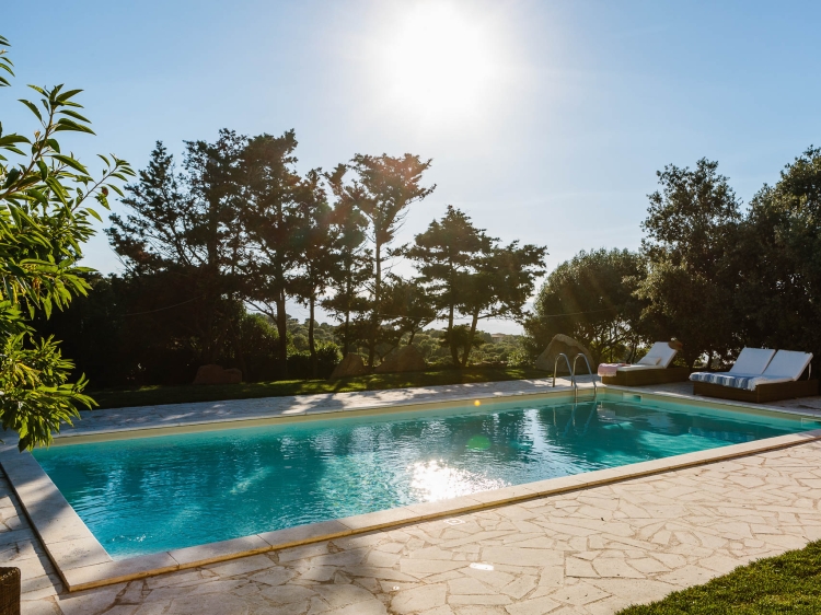 Vista soleada de la piscina y las tumbonas del Borgo Lu Puleu